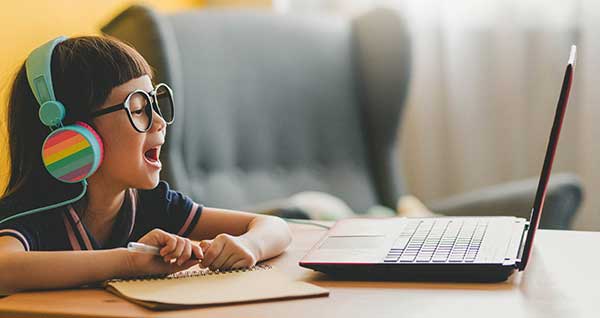 photo of young girl using laptop