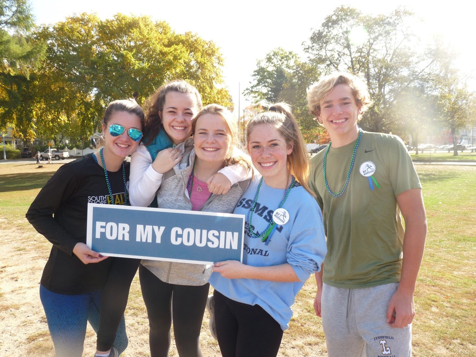 group of teens at wakefield steps2cure walk, holding "for my cousin" sign